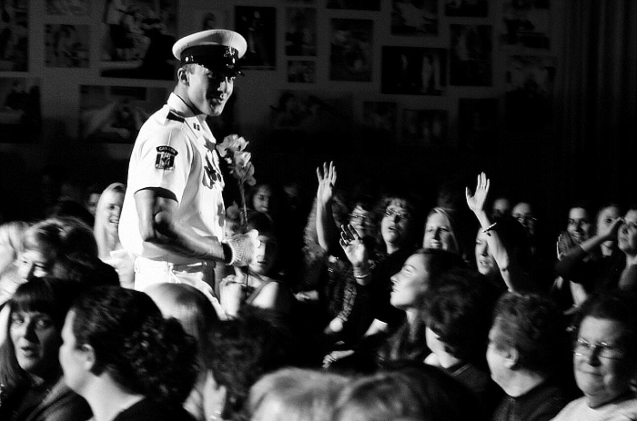 Canadian Storm - Tom Rooney professional picture performing in audience Black and white photo of headline Performer Thomas (Tom) Rooney in Canadian Storm Male Revue performing as a naval officer and surrounded by an audience of enthusiastic women